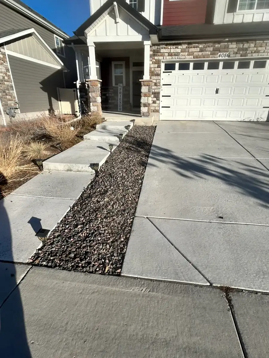 Concrete walkway and driveway with decorative rock border in Denver, Colorado